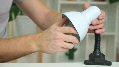 A man changes an electric lamp. Warm yellow light. Replacement an energy-saving Stock Footage 220886048