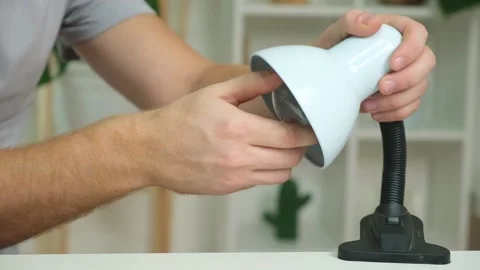 A man changes an electric lamp. Warm yellow light. Replacement an energy-saving Stock Footage 223228996