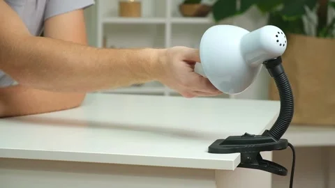 A man changes an electric lamp. Warm yellow light. Replacement an energy-saving Stock Footage 224372934