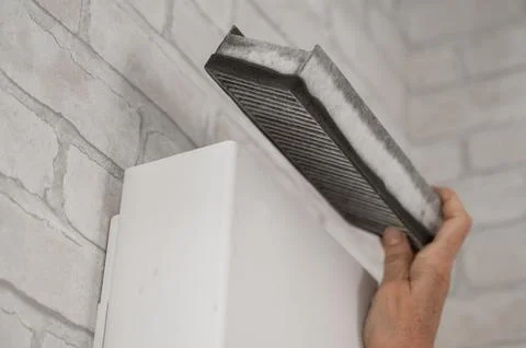 A man changes the filter at the supply ventilation. Gadget for ventilation Stock Photos