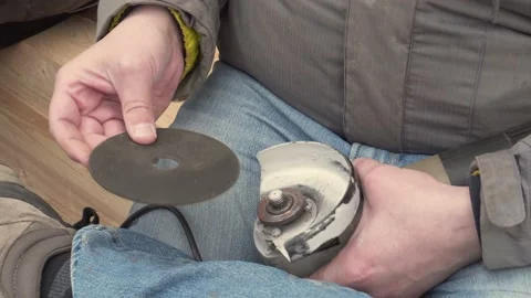 A man changes grinding wheel on an angle grinder. Stock Footage 157286851