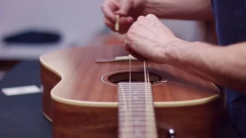 Man changes guitar strings Stockbeeldmateriaal 102058113