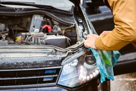 A man changes his headlights. Replacing the headlight lamps, the hood is open Stock-Fotos