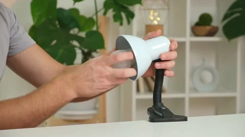 The man changes lamp. Energy-saving lamp. Replacement of an energy-saving lamp. Stock Footage 217511702