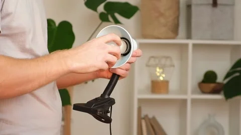 The man changes lamp. Energy-saving lamp. Replacement of an energy-saving lamp. Stock Footage 217511762