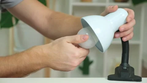 The man changes lamp. Energy-saving lamp. Replacement of an energy-saving lamp. Stock Footage 218162613