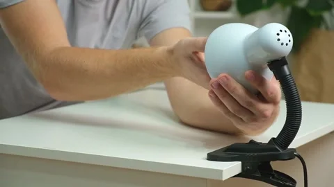The man changes lamp. Energy-saving lamp. Replacement of an energy-saving lamp. Stock Footage 221583137