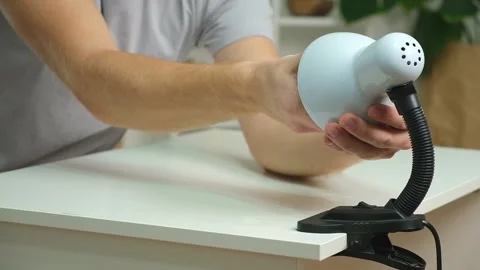 The man changes lamp. Energy-saving lamp. Replacement of an energy-saving lamp. Stock Footage 222016485
