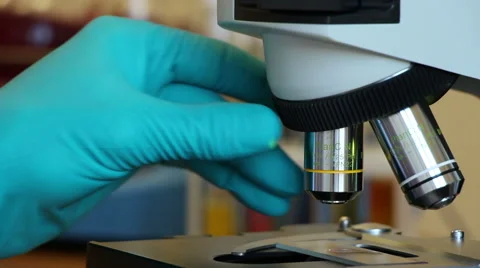 A man changes an objectives of microscope Stock Footage 63045499