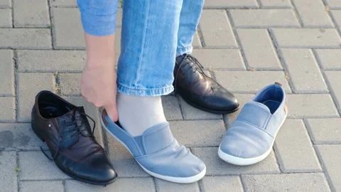 A man changes shoes into light sneakers without laces Stock-Footage 137098471