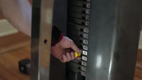 Of man changes weight plate weight machine at the gym to increase the load. Stock Footage 166302507