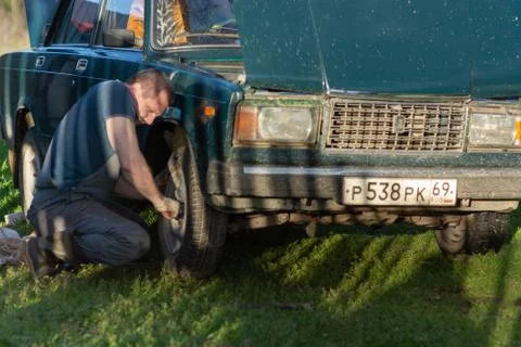 A man changes a wheel on a car. Stock Photos