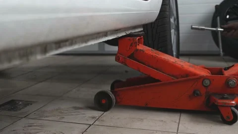 A man changes the wheel of a car while in the car service room, selective focus. Video stock 182916324