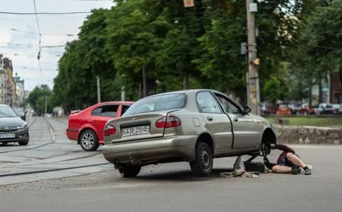 Man changes the wheel on the road Stock Photos