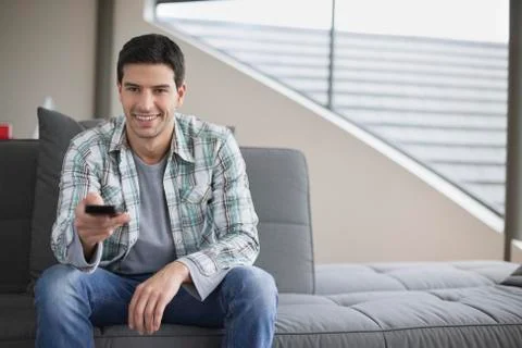 Man changing channels with a remote control Stock Photos