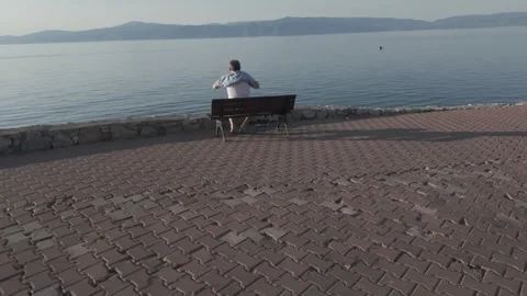 Man Changing Clothes on Bench by Beach Stock Footage 310945548