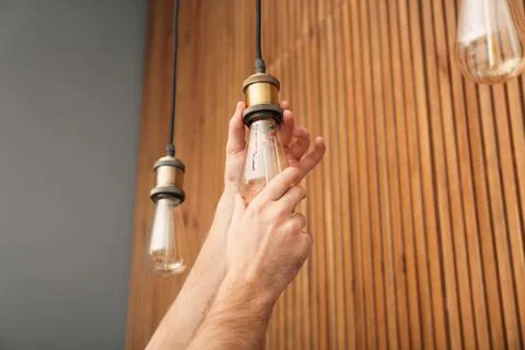 Man changing lamp light bulb indoors, closeup Stock Photos