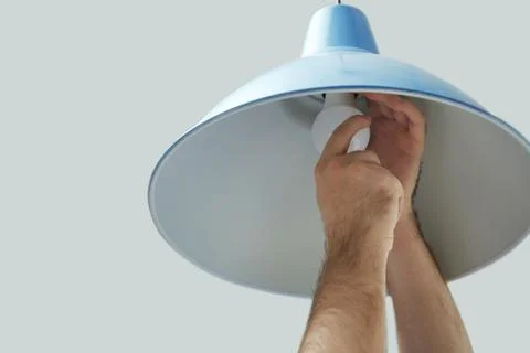 Man changing light bulb in lamp on white background, closeup Stock Photos