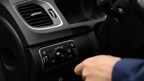 Man changing modes of headlights in car Stock Footage 76530465