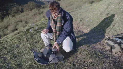 A man changing ND filter of his drone with camera to fly in a beautiful lan.. Stock Footage 240397227