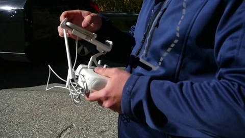 Man changing a settings on his phantom 4 pro drone remote control, before the Stock Footage 84571257