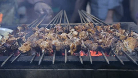 A man changing the sides of seekh kebab to cook from all sides Stock Footage 112773154