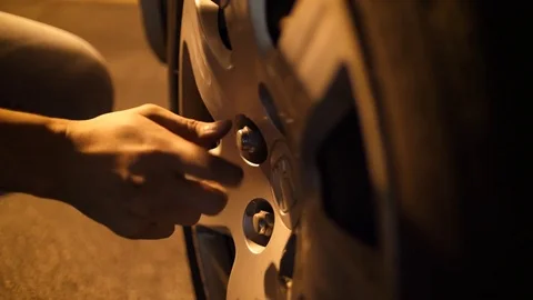 Man Changing at Tire Close Up on Hand Loosening Nut Video stock 80474770