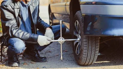Man changing wheel on a car Photos