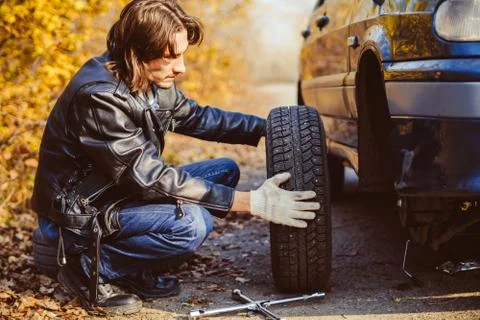 Man changing wheel on a car Photos
