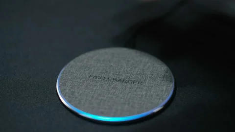 Man charge Smartphone Using Wireless Charging base ,hi technology device 4k Stock Footage 166589628