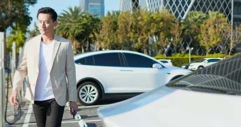 Man Charges electric car Stock Footage 128326341