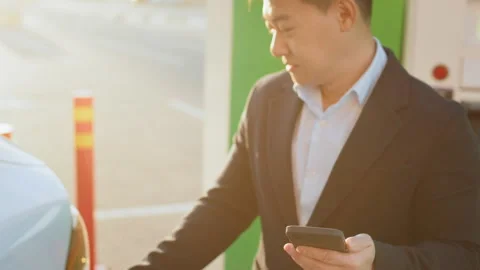 Man charging car and using smartphone. Crop of male hand inserting charging Stock Footage 245259534
