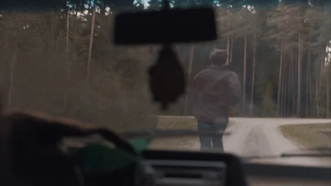 Man chased by a car through the forest road Stock Footage 83222923
