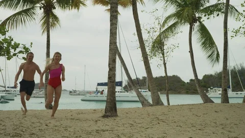 Man chasing and catching then kissing woman on beach / Salt Whistle Bay, Stock Footage 114765124