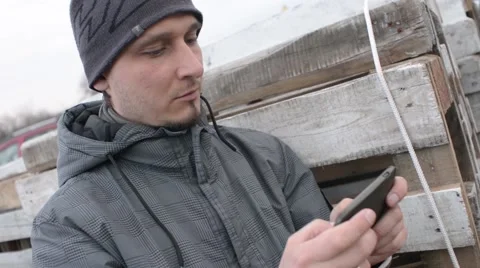 Man chating wrighting sms via Cell Mobile Phone standing on the Wood Stock Stock Footage 61193769