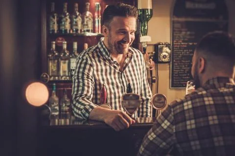 Man chatting with a bartender in a pub Stock Photos