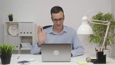 Man is chatting with colleagues by video chat on laptop during daily online Stock Footage 147335486
