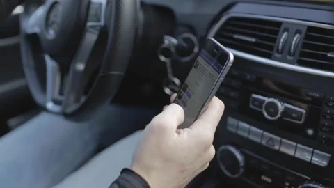 Man chatting on the phone while driving a car on a bright day Stock Footage 147488236