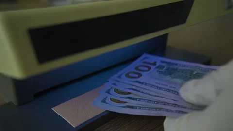 Man check bills on bill detector with violet light. Stock Footage 307755778