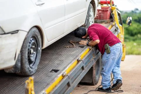 A man check chain bind car wheel on car tow in the park. Damage and accident  Stock Photos