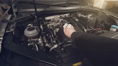 Man check engine oil level in car with open hood in garage Video stock 151393567