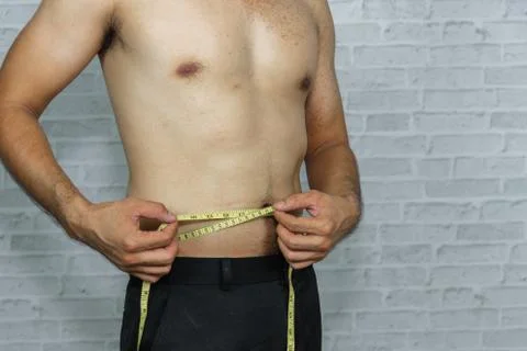 Man check out his body fat with measuring tape Stock Photos