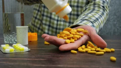 Man in checkered shirt opens pill bottle and fill hand Vídeos de archivo 235932141