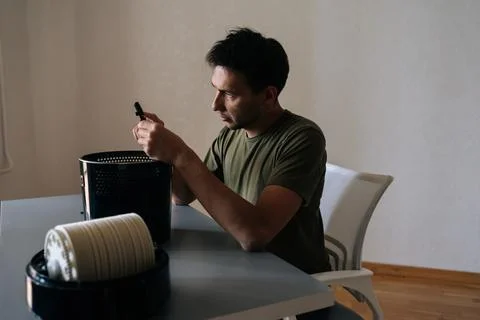 Man checking air humidifier filter, carefully examining device component for Stock Photos