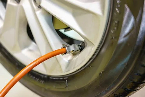 Man checking air pressure and filling air in the tires of his car Stockfoto's