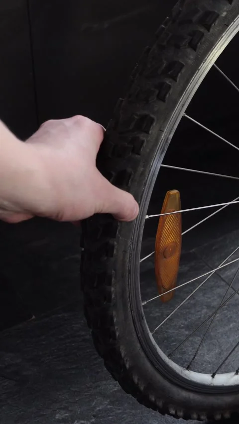 Man checking air pressure on flat bicycle tire, vertical format Stock Footage 335090802