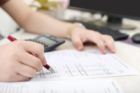 Man is checking balance sheet with pen Stock Photos