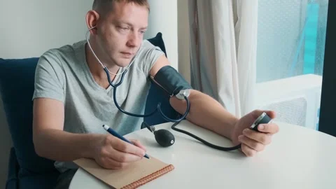Man checking blood pressure with manual sphygmomanometer and stethoscope and Stock Footage 315861848