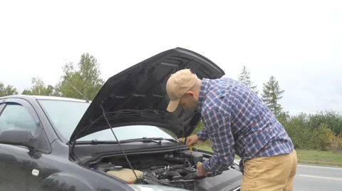 Man checking car engine oil, vehicle safety. The driver on the road at the ro Video stock 67509965