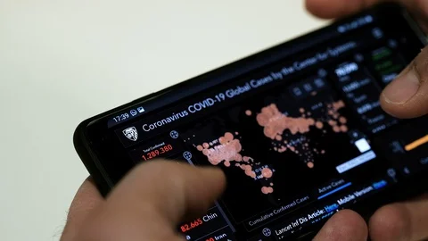 Man checking Coronavirus COVID-19 Global Cases on smartphone,tech news info Stock Footage 127867943